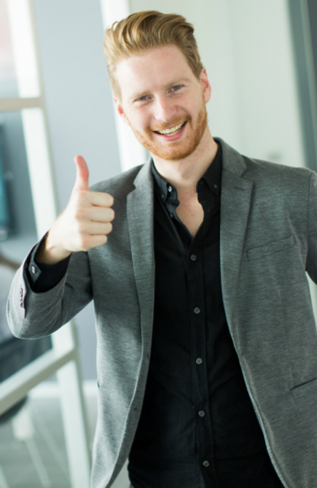 smiling blond man showing a thumps up sign